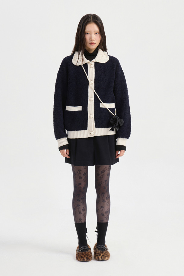 다크 네이비 컬러의 Colored Collar 니트 풀오버입니다. 부드러운 울 소재로 제작되어 가을과 겨울에 따뜻하게 착용할 수 있습니다. 페미닌하고 캐주얼한 무드를 연출하며, 루즈핏과 긴 소매 기장으로 편안함을 더했습니다. 배색 프릴 카라와 금속 버튼, 앞 포켓, 뒷면 그래픽 디자인이 특징입니다. 데이트룩, 모임룩, 캐주얼, 클래식, 미니멀 스타일 모두 소화 가능한 아이템입니다.
