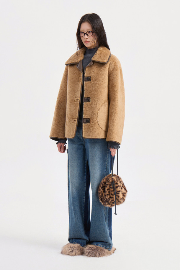 포근하고 부드러운 페이크 퍼 소재의 카멜 컬러 점퍼입니다. 캐주얼, 미니멀, 클래식 스타일을 아우르며, 가을, 겨울 시즌 데이트룩, 모임룩에 활용하기 좋습니다. 크롭 기장에 루즈핏 또는 오버핏으로 연출 가능하며, 2WAY 착용 가능한 리버시블 디자인과 아웃포켓, 페이크 레더 파이핑 디테일이 특징입니다. 긴 소매에 버튼 여밈 방식으로 편안하게 착용할 수 있습니다. 두께감 있는 소재로 따뜻함과 스타일을 동시에 잡아보세요.
