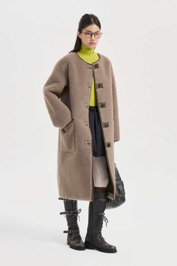 부드러운 촉감의 브라운 컬러 페이크 퍼 롱 코트입니다. 오버핏 디자인에 맥시 기장으로, 가을과 겨울에 따뜻하게 착용할 수 있습니다. 겉감은 울, 인조가죽, 퍼 소재로, 안감은 리버시블 디자인으로 제작되어 다양한 스타일을 연출할 수 있습니다. 싱글 버튼 여밈 방식과 아웃포켓 디테일이 돋보이며, 데이트룩, 캐주얼, 클래식, 미니멀 스타일 모두 소화 가능합니다. 시어링 코트 스타일로, 페이크 레더 마감 처리된 오버사이즈 코트입니다.
