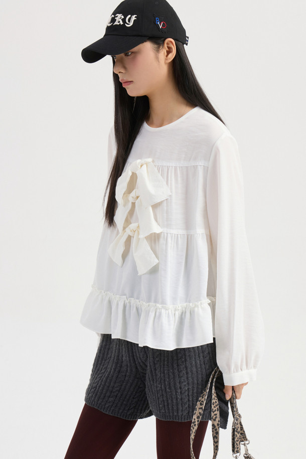 리본 포인트 칼라리스 블라우스 (아이보리)는 부드러운 텐셀 혼방 소재로 제작되어 은은한 광택과 고급스러운 분위기를 자아냅니다. 라운드 넥 디자인에 셔링 디테일과 밑단 프릴, 리본 포인트로 페미닌한 무드를 더했으며, 뒷넥 단추 여밈으로 간편하게 착용할 수 있습니다. 여유로운 루즈핏 실루엣으로 편안하면서도 스타일리시하게 연출 가능하며, 데이트룩, 카페룩, 모임룩 등 다양한 TPO에 활용하기 좋습니다. 클래식, 미니멀, 로맨틱 스타일을 즐겨 입는 여성분들께 추천하는 아이보리 컬러의 긴소매 블라우스입니다.
