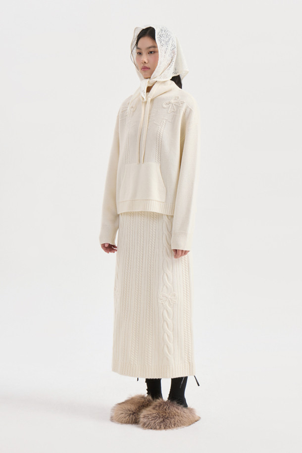 아이보리 색상의 리본 니트 풀오버는 부드러운 메리노 울 100% 소재로 제작되어 포근한 착용감을 선사합니다. 루즈핏으로 편안하게 착용 가능하며, 케이블 패턴과 캥거루 포켓, 리본 디테일이 더해져 캐주얼하면서도 여성스러운 분위기를 연출합니다. 후드 네크라인과 긴 소매 기장으로 가을, 겨울철 따뜻하게 입을 수 있으며, 스트링 조절이 가능하여 핏을 조절할 수 있습니다. 집콕룩, 산책룩, 여행룩 등 다양한 TPO에 활용할 수 있는 베이직하고 미니멀한 스타일의 니트입니다.
