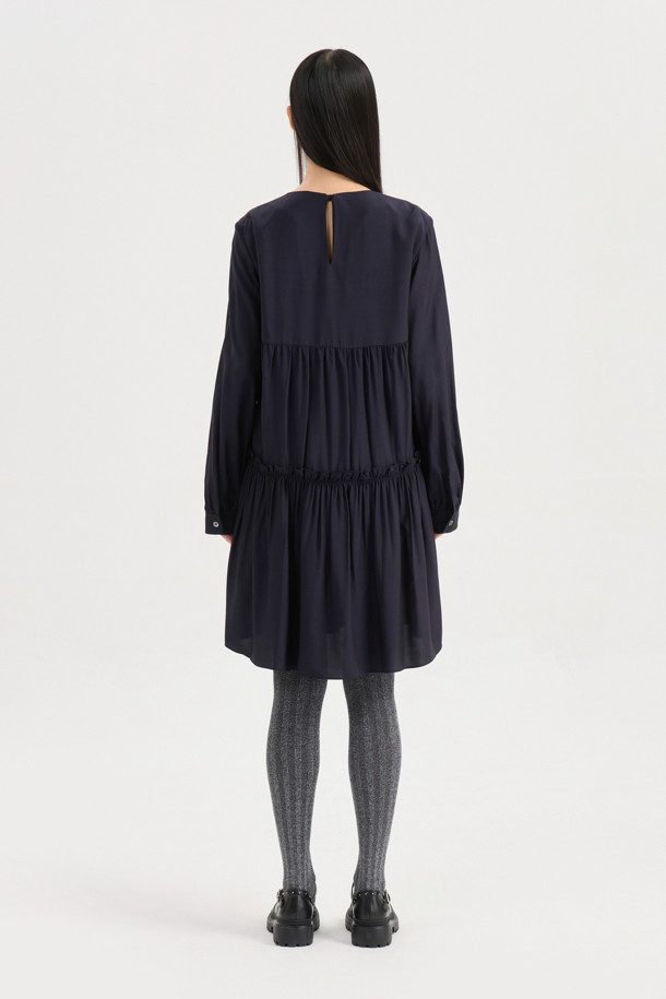 다크 네이비 컬러의 셔링 디테일 라운드넥 원피스입니다. 부드러운 레이온 소재로 제작되어 편안한 착용감을 선사하며, 루즈핏과 플레어 A라인 치마가 자연스러운 실루엣을 연출합니다. 허리선 아래 셔링으로 볼륨감을 더하고, 허리 부분 로고 테이프로 포인트를 주었습니다. 긴 소매와 뒷넥 단추 여밈으로 클래식하면서도 캐주얼한 분위기를 자아내 데이트룩, 모임룩, 또는 미니멀한 스타일을 연출하고 싶은 날에 적합합니다. 사계절 내내 활용 가능한 실용적인 아이템입니다.
