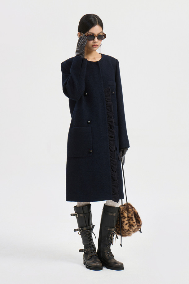 다크 네이비 컬러의 Center Frill 라운드 넥 코트입니다. 페미닌과 캐주얼 무드를 동시에 연출할 수 있으며, 가을과 겨울에 따뜻하게 입을 수 있는 두꺼운 울 소재로 제작되었습니다. 드롭 숄더, 프릴 디테일, 금속 단추, 로고 패턴 안감, 포켓 디테일이 돋보이는 롱 기장의 싱글 버튼 코트입니다. 데이트룩, 오피스룩, 모임룩 등 다양한 TPO에 활용 가능하며, 클래식, 미니멀, 캐주얼 스타일을 즐기는 여성에게 추천합니다.
