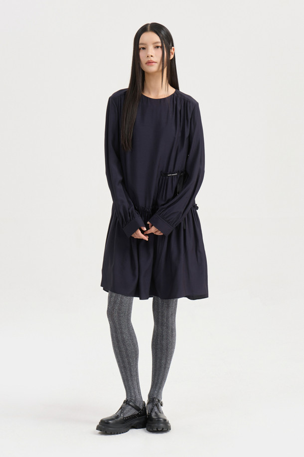 다크 네이비 컬러의 셔링 디테일 라운드넥 원피스입니다. 부드러운 레이온 소재로 제작되어 편안한 착용감을 선사하며, 루즈핏과 플레어 A라인 치마가 자연스러운 실루엣을 연출합니다. 허리선 아래 셔링으로 볼륨감을 더하고, 허리 부분 로고 테이프로 포인트를 주었습니다. 긴 소매와 뒷넥 단추 여밈으로 클래식하면서도 캐주얼한 분위기를 자아내 데이트룩, 모임룩, 또는 미니멀한 스타일을 연출하고 싶은 날에 적합합니다. 사계절 내내 활용 가능한 실용적인 아이템입니다.
