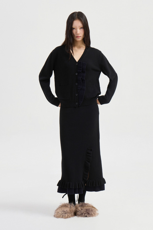 블랙 프릴 롱 니트 스커트는 가을, 겨울 시즌에 어울리는 여성용 스커트입니다. 울, 캐시미어, 나일론 혼방의 부드러운 소재와 두꺼운 두께감으로 따뜻하고 포근한 착용감을 선사합니다. A라인 핏에 허리 밴딩, 사이드 트임, 러플 디테일이 더해져 엘레강스한 무드를 연출하며, 데이트룩, 모임룩, 오피스룩 등 다양한 TPO에 활용 가능합니다. 미니멀, 클래식, 시크 스타일을 즐겨 입는 분들께 추천하며, 세트 상품으로도 연출할 수 있습니다. 맥시 기장으로 우아함을 더해줍니다.
