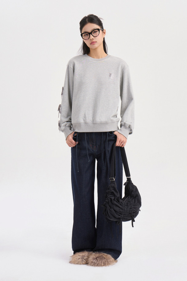 멜란지 그레이 컬러의 리본 포인트 맨투맨 티셔츠입니다. 캐주얼하고 미니멀한 스타일로, 봄, 가을에 어울리는 크롭 기장의 긴소매 디자인입니다. 오른쪽 소매에는 벨벳 리본 장식이, 가슴에는 슈에뜨 자수가 포인트로 자리 잡고 있습니다. 슬림핏으로 제작되어 더욱 세련된 핏을 연출하며, 일상에서 편안하게 착용할 수 있는 웨어러블 아이템입니다. 라운드넥으로 제작되어 어떤 스타일에도 잘 어울립니다.
