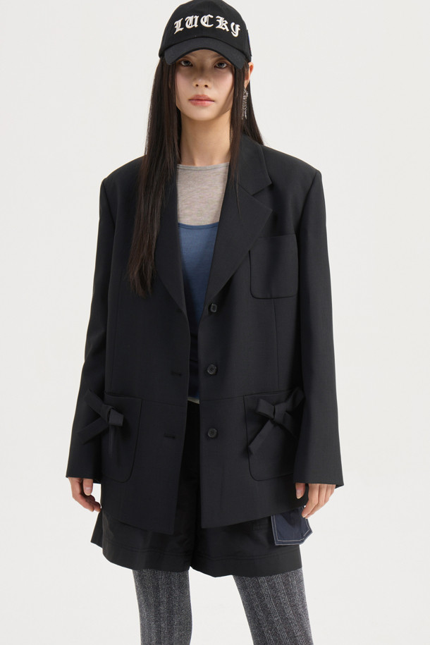 리본 디테일 폴리 싱글 재킷 (Ribbon Detail Poly Single Jacket, 블랙)은 클래식과 캐주얼 무드를 동시에 연출하는 여성 자켓입니다. 두껍고 뻣뻣한 폴리에스테르 소재로 제작되어 봄, 가을에 착용하기 좋으며, 중힙 기장의 박시 핏으로 편안한 착용감을 선사합니다. 싱글 버튼 여밈 방식에 리본 디테일 포켓이 더해져 포인트를 더하고, 안감에는 럭키 (LUCKY) 로고 패턴이, 소매 안감에는 스트라이프 패턴이 적용되어 있습니다. 소매는 레터링 테이프로 턴업하여 다양한 스타일을 연출할 수 있으며, 출근룩, 오피스룩, 모임룩 등 TPO에 맞춰 미니멀하고 세련된 스타일을 완성해보세요.
