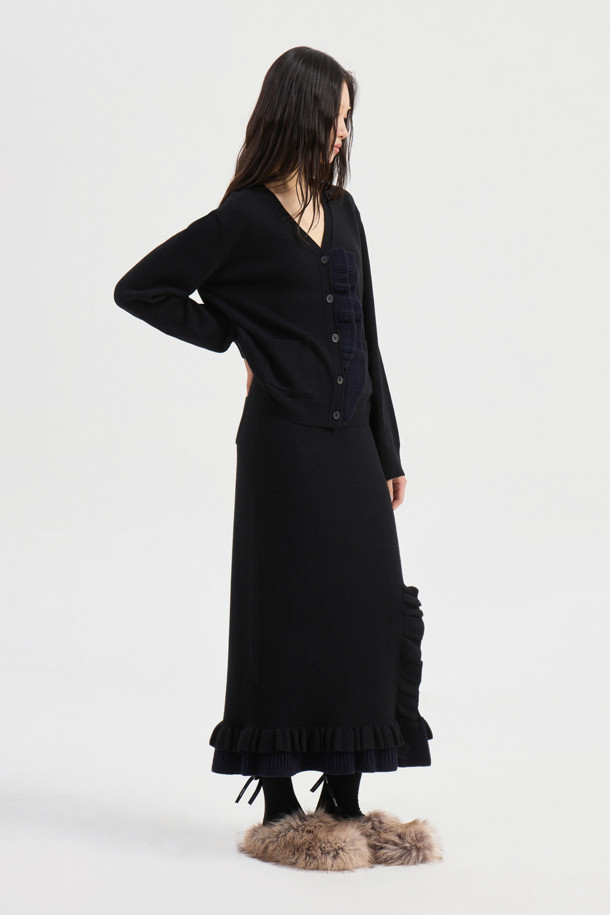 블랙 프릴 롱 니트 스커트는 가을, 겨울 시즌에 어울리는 여성용 스커트입니다. 울, 캐시미어, 나일론 혼방의 부드러운 소재와 두꺼운 두께감으로 따뜻하고 포근한 착용감을 선사합니다. A라인 핏에 허리 밴딩, 사이드 트임, 러플 디테일이 더해져 엘레강스한 무드를 연출하며, 데이트룩, 모임룩, 오피스룩 등 다양한 TPO에 활용 가능합니다. 미니멀, 클래식, 시크 스타일을 즐겨 입는 분들께 추천하며, 세트 상품으로도 연출할 수 있습니다. 맥시 기장으로 우아함을 더해줍니다.
