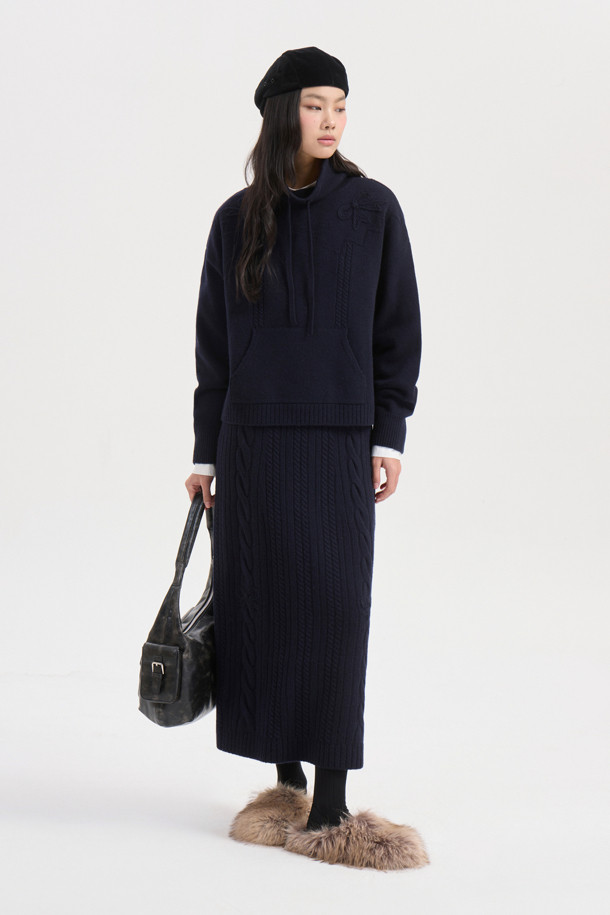 다크 네이비 색상의 리본 니트 스커트입니다. 메리노 울 소재로 제작되어 부드러운 촉감과 따뜻함을 선사하며, 가을/겨울 시즌에 적합합니다. 세미 A라인 핏에 밑단 립조직과 케이블/립조직 패턴이 우아하고 클래식한 분위기를 연출합니다. 허리 부분의 리본 디테일이 여성스러운 포인트를 더하며, 체형 커버에도 효과적입니다. 출근룩과 모임룩 모두 소화 가능한 활용도 높은 맥시 스커트로, 셋업 연출도 가능합니다.
