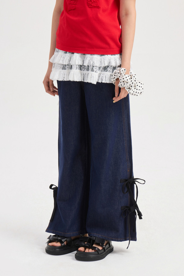 럭키슈에뜨 Side Ribbon Wide Denim Pants (dark blue)는 여성용 와이드핏 데님 팬츠입니다. 양 사이드 리본 디테일과 럭키슈에뜨 로고 캔톤, 리벳 장식, 뒤 포켓 개발 스티치 자수가 특징이며, 캐주얼 및 스트릿 스타일 연출에 용이합니다. 봄, 여름, 가을 시즌 일상복으로 활용하기 좋으며, 맥시 기장의 다크 블루 컬러 데님 소재로 제작되었습니다.
