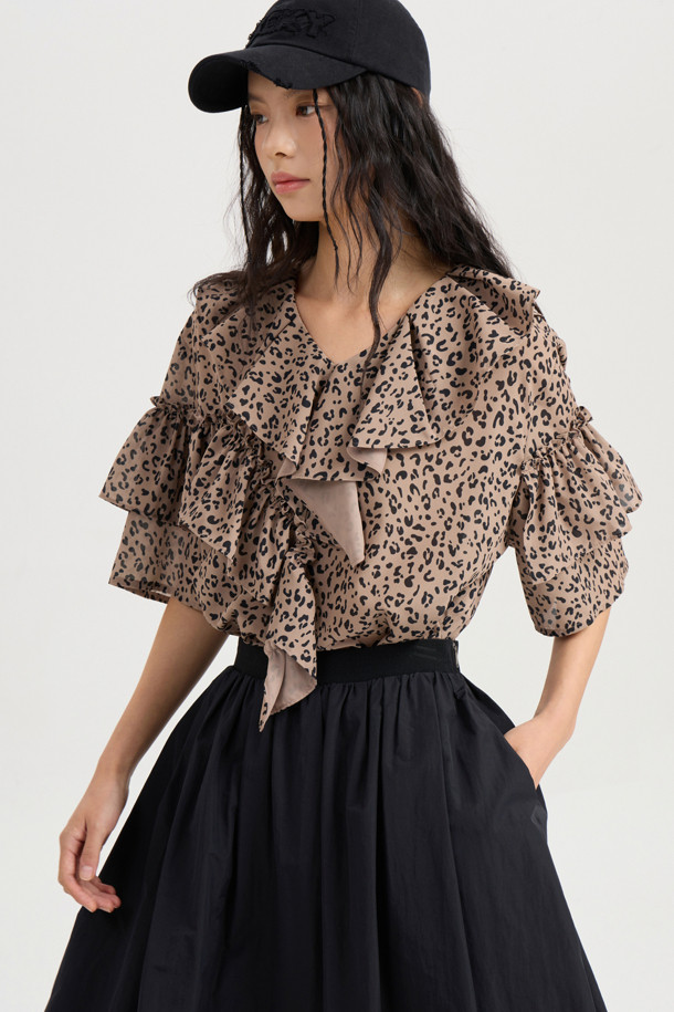 **Ruffle Point Leopard 블라우스 (브라운)**

페미닌하고 클래식한 무드를 연출하는 Ruffle Point Leopard 블라우스입니다. 브라운 컬러의 레오파드(호피) 패턴이 특징이며, 봄, 여름, 가을 계절에 활용하기 좋습니다. 루즈핏으로 편안하게 착용 가능하며, 비대칭 네크라인과 긴소매, 소매 셔링, 볼륨감있는 디자인이 돋보입니다. 뒷넥 단추 여밈으로 간편하게 탈착용할 수 있으며, 데이트룩, 카페룩, 모임룩 등 다양한 TPO에 맞춰 클래식, 로맨틱, 미니멀 스타일을 연출해보세요.
