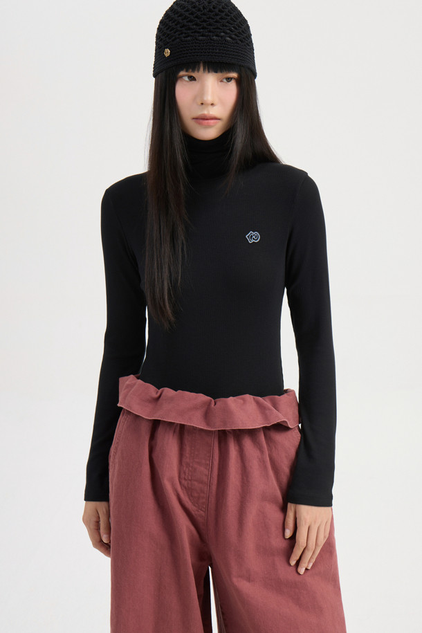 **[Re-Order] 골지 터틀넥 긴소매 티셔츠 (블랙)**

부드러운 면 소재로 제작되어 편안한 착용감을 선사하는 블랙 컬러의 터틀넥 티셔츠입니다. 슬림핏 디자인으로 여성스러운 실루엣을 강조하며, 가을/겨울 시즌에 적합합니다. 베이직한 스타일로 다양한 룩에 활용하기 좋으며, 이너 또는 레이어드용으로 활용도가 높습니다. 왼쪽 가슴 부분의 엠블럼 자수 디테일이 돋보이며, 출근룩, 미니멀, 클래식, 캐주얼 스타일을 즐기는 분들께 추천합니다. 얇은 두께감과 긴 소매 기장으로 간절기부터 겨울까지 따뜻하게 착용할 수 있습니다.
