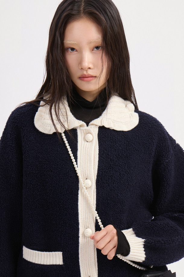 다크 네이비 컬러의 Colored Collar 니트 풀오버입니다. 부드러운 울 소재로 제작되어 가을과 겨울에 따뜻하게 착용할 수 있습니다. 페미닌하고 캐주얼한 무드를 연출하며, 루즈핏과 긴 소매 기장으로 편안함을 더했습니다. 배색 프릴 카라와 금속 버튼, 앞 포켓, 뒷면 그래픽 디자인이 특징입니다. 데이트룩, 모임룩, 캐주얼, 클래식, 미니멀 스타일 모두 소화 가능한 아이템입니다.
