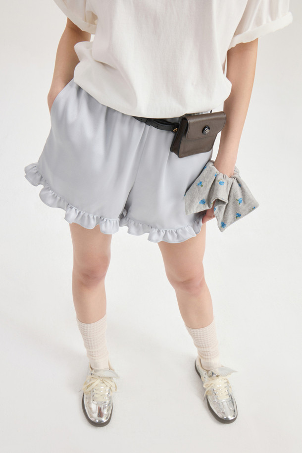 럭키슈에뜨의 Chouetties 프릴 숏팬츠 (실버)는 여성스러운 무드를 연출하는 숏 기장의 프릴 숏팬츠입니다. 은은한 광택감이 돋보이는 사틴 소재에 도트 무늬가 더해져 로맨틱하면서도 미니멀한 스타일을 완성합니다. 밑단 러플 디테일로 포인트를 더했으며, 루즈핏으로 편안한 착용감을 선사합니다. 데이트룩, 카페룩, 휴가룩 등 다양한 TPO에 활용 가능하며, 밴딩 처리로 활동성을 높였습니다. 뒷면에는 럭키슈에뜨 라벨 장식이 돋보입니다.
