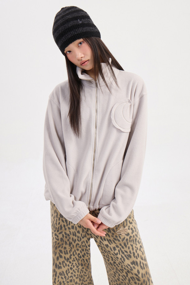 럭키슈에뜨의 Chouetties (슈에티스) by LUCKY CHOUETTE_Moon Motive 플리스 점퍼 (라이트 베이지)는 캐주얼 무드의 여성용 아우터입니다. 가을과 겨울, 일상에서 산책룩, 캠핑룩 등 다양한 TPO에 활용 가능하며, 미니멀, 고프코어 스타일을 연출하기 좋습니다. 부드러운 플리스 소재에 두꺼운 두께감으로 따뜻함을 더하고, 루즈핏 디자인으로 편안한 착용감을 제공합니다. 소매단 밴딩과 밑단 스트링, 네크라인 테이프 처리, 그리고 Lucky Crescent Moon 모티브 패치가 포인트입니다. 지퍼형 여밈 방식과 긴 소매 기장으로 실용성을 높였습니다.
