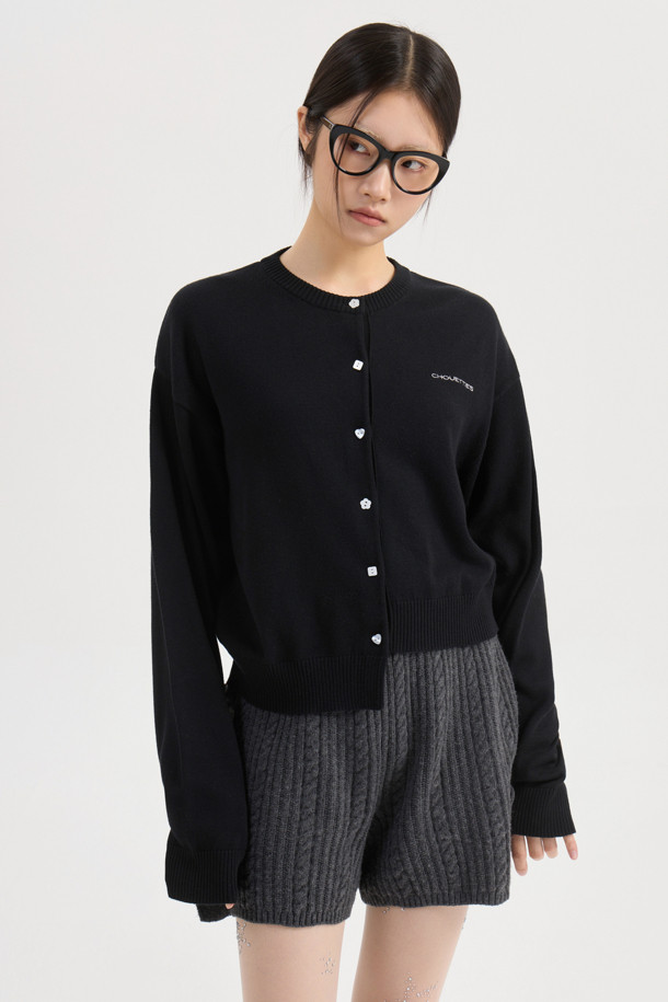 LUCKY CHOUETTE (럭키슈에뜨)의 언밸런스 니트 가디건 (black)입니다. 봄, 가을에 어울리는 캐주얼 스타일의 여성 의류로, 부드러운 아크릴과 코튼 혼방 소재로 제작되어 편안한 착용감을 선사합니다. 라운드넥에 루즈핏으로, 데이트룩 또는 카페룩에 잘 어울립니다. 세 가지 모양의 믹스된 단추와 좌우 언밸런스한 기장, 레터링 자수 포인트가 특징입니다. 미니멀하고 클래식한 무드를 연출하기 좋습니다.
