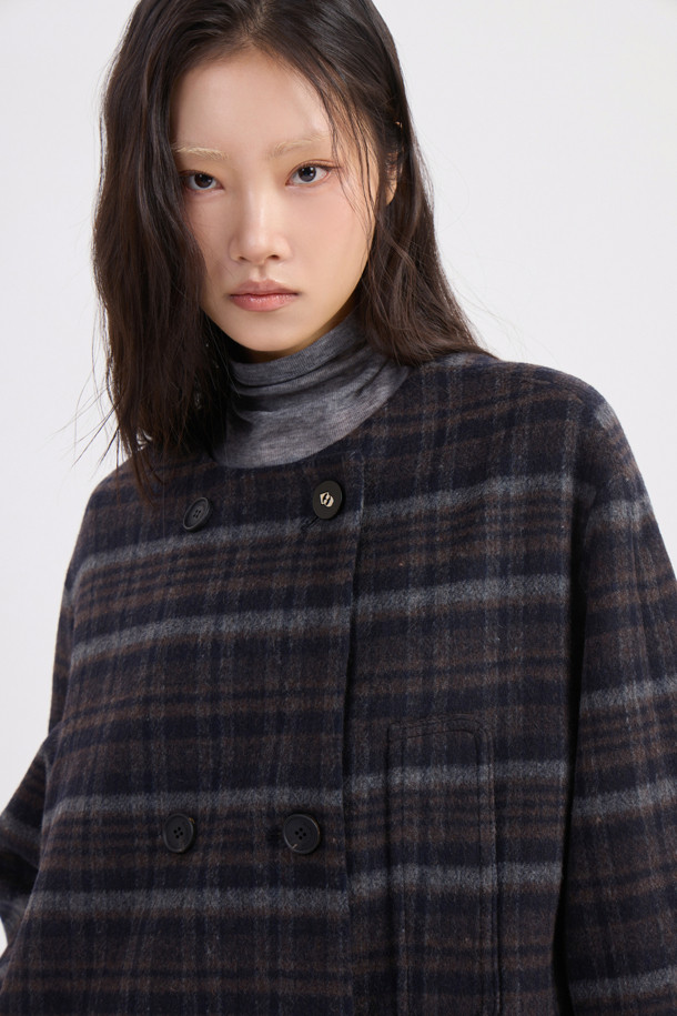 다크 네이비 컬러의 라운드 넥 프릴 디테일 더블 코트입니다. 캐시미어와 울 혼방 소재로 제작되어 부드러운 촉감과 뛰어난 보온성을 제공하며, 가을/겨울 시즌에 착용하기 좋습니다. 페미닌한 무드의 루즈핏으로, 톤온톤 체크 패턴과 로고 단추, 리본 디테일이 돋보입니다. 안감은 로고 패턴으로 마감되었으며, 더블 버튼 여밈과 긴 소매 기장으로 클래식하고 여성스러운 스타일을 연출합니다. 오피스룩, 모임룩, 데이트룩 등 다양한 TPO에 활용할 수 있습니다.

