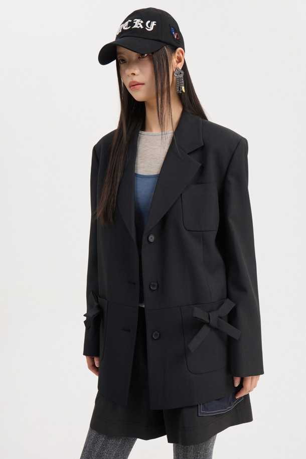 리본 디테일 폴리 싱글 재킷 (Ribbon Detail Poly Single Jacket, 블랙)은 클래식과 캐주얼 무드를 동시에 연출하는 여성 자켓입니다. 두껍고 뻣뻣한 폴리에스테르 소재로 제작되어 봄, 가을에 착용하기 좋으며, 중힙 기장의 박시 핏으로 편안한 착용감을 선사합니다. 싱글 버튼 여밈 방식에 리본 디테일 포켓이 더해져 포인트를 더하고, 안감에는 럭키 (LUCKY) 로고 패턴이, 소매 안감에는 스트라이프 패턴이 적용되어 있습니다. 소매는 레터링 테이프로 턴업하여 다양한 스타일을 연출할 수 있으며, 출근룩, 오피스룩, 모임룩 등 TPO에 맞춰 미니멀하고 세련된 스타일을 완성해보세요.
