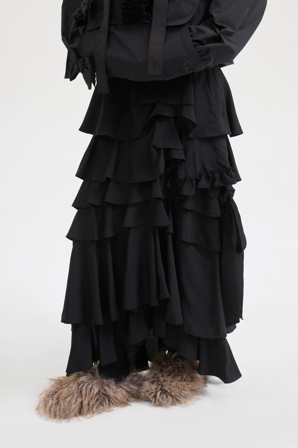 [Atelier] 프릴 포인트 롱 스커트 (블랙)는 여성 고객을 위한 클래식하고 유니크한 스타일의 롱 스커트입니다. 부드러운 레이온 소재로 제작되어 사계절 내내 편안하게 착용할 수 있으며, 세미 A라인 핏으로 여성스러운 실루엣을 연출합니다. 밑단 트임과 리본, 프릴 디테일이 돋보이며, 옆 지퍼로 간편하게 착용할 수 있습니다. 데이트룩, 카페룩, 모임룩 등 다양한 TPO에 활용 가능하며, 미니멀, 시크 스타일을 선호하는 분들께 추천합니다. 활동성이 좋아 편안하게 움직일 수 있으며, 다양한 상의와 매치하여 폭넓은 스타일을 연출할 수 있습니다.
