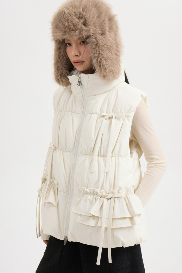 리본 디테일이 돋보이는 [Re-Order] 리본 다운 베스트는 페미닌한 무드를 연출합니다. 부드러운 유연함을 자랑하는 나일론, 스판덱스 혼방 소재로 제작되어 편안한 착용감을 선사합니다. 숏 기장과 투웨이 지퍼 여밈으로 세련된 실루엣을 강조하며, 셔링 디테일과 샤이니 안감이 고급스러움을 더합니다. 데이트룩, 모임룩 등 다양한 TPO에 활용 가능한 아이보리 컬러의 겨울철 필수 아이템입니다. 구스다운 충전재와 패딩 안감으로 보온성을 높였습니다.
