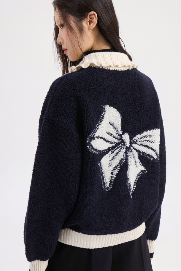 다크 네이비 컬러의 Colored Collar 니트 풀오버입니다. 부드러운 울 소재로 제작되어 가을과 겨울에 따뜻하게 착용할 수 있습니다. 페미닌하고 캐주얼한 무드를 연출하며, 루즈핏과 긴 소매 기장으로 편안함을 더했습니다. 배색 프릴 카라와 금속 버튼, 앞 포켓, 뒷면 그래픽 디자인이 특징입니다. 데이트룩, 모임룩, 캐주얼, 클래식, 미니멀 스타일 모두 소화 가능한 아이템입니다.
