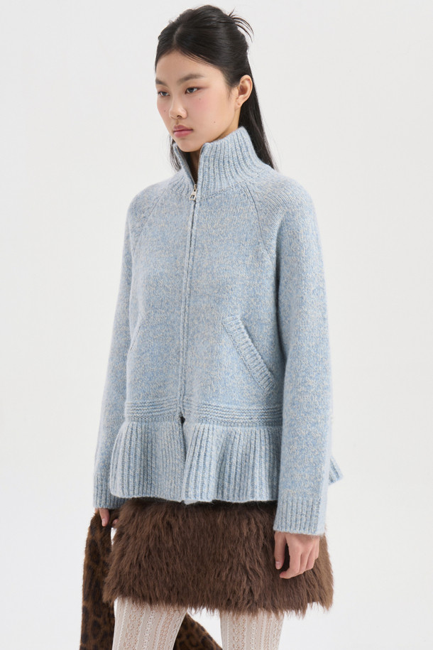 라이트 블루 컬러의 자수 포인트 집업 니트 가디건입니다. 래글런 소매와 하이넥 디자인으로 따뜻함과 스타일을 동시에 잡았습니다. 두꺼운 두께감의 니트 소재에, MULINE 타입 원사를 사용하여 포근한 착용감을 선사합니다. 등판 로고와 핸드메이드 자수 디테일이 유니크한 포인트를 더하며, 밑단 러플과 페플럼 디자인으로 여성스러운 실루엣을 연출합니다. 금속 지퍼로 간편하게 여밀 수 있으며, 가을, 겨울철 캐주얼 룩에 활용하기 좋습니다.
