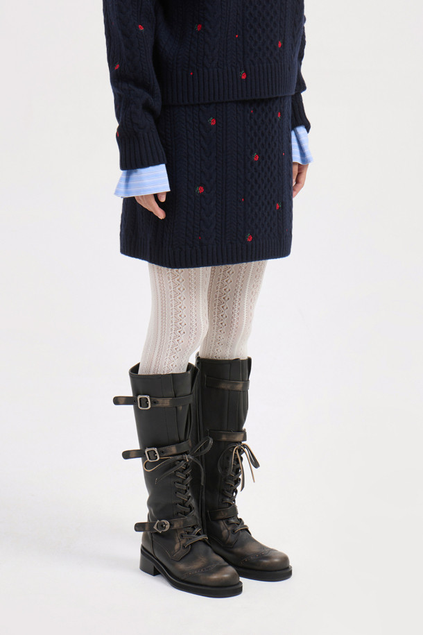 다크 네이비 컬러의 케이블 자수 니트 스커트입니다. 울, 캐시미어, 나일론 혼방 소재로 제작되어 부드러운 촉감과 두꺼운 두께감으로 따뜻하게 착용할 수 있습니다. H라인 미니스커트 디자인에 허리 밴딩, 자수 디테일, 니트 조직감이 더해져 미니멀하면서도 베이직한 스타일을 연출합니다. 가을, 겨울 시즌 데이트룩, 출근룩, 모임룩 등 다양한 TPO에 클래식, 미니멀, 시크한 무드로 활용하기 좋습니다. 레귤러핏으로 편안하게 착용 가능하며, 케이블 패턴과 플라워 자수 무늬가 특징입니다.
