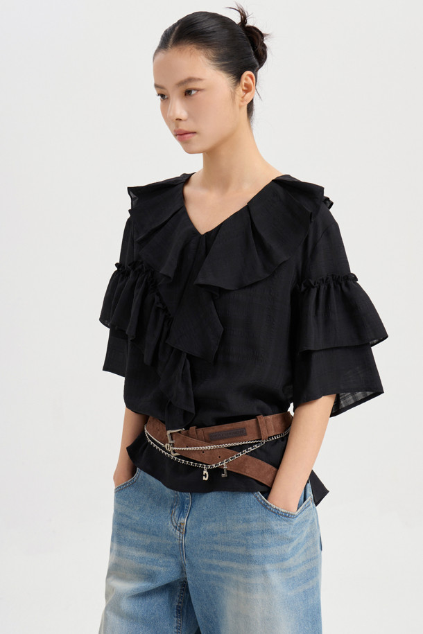 **러플 포인트 체크 블라우스 (블랙)**

페미닌한 무드의 여성 블라우스입니다. 봄, 여름 시즌에 어울리는 얇은 두께감의 폴리에스테르, 레이온 혼방 소재로 제작되었습니다. 루즈핏에 V넥 디자인이며, 러플 디테일과 비대칭 네크라인이 특징입니다. 반소매 소매 셔링과 뒷넥 단추 여밈으로 여성스러운 포인트를 더했습니다. 데이트룩, 카페룩, 모임룩 등 다양한 TPO에 클래식, 미니멀, 로맨틱 스타일로 연출하기 좋습니다.
