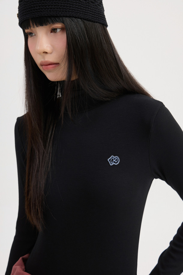 **[Re-Order] 골지 터틀넥 긴소매 티셔츠 (블랙)**

부드러운 면 소재로 제작되어 편안한 착용감을 선사하는 블랙 컬러의 터틀넥 티셔츠입니다. 슬림핏 디자인으로 여성스러운 실루엣을 강조하며, 가을/겨울 시즌에 적합합니다. 베이직한 스타일로 다양한 룩에 활용하기 좋으며, 이너 또는 레이어드용으로 활용도가 높습니다. 왼쪽 가슴 부분의 엠블럼 자수 디테일이 돋보이며, 출근룩, 미니멀, 클래식, 캐주얼 스타일을 즐기는 분들께 추천합니다. 얇은 두께감과 긴 소매 기장으로 간절기부터 겨울까지 따뜻하게 착용할 수 있습니다.
