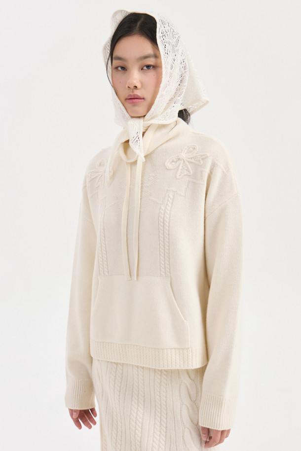 아이보리 색상의 리본 니트 풀오버는 부드러운 메리노 울 100% 소재로 제작되어 포근한 착용감을 선사합니다. 루즈핏으로 편안하게 착용 가능하며, 케이블 패턴과 캥거루 포켓, 리본 디테일이 더해져 캐주얼하면서도 여성스러운 분위기를 연출합니다. 후드 네크라인과 긴 소매 기장으로 가을, 겨울철 따뜻하게 입을 수 있으며, 스트링 조절이 가능하여 핏을 조절할 수 있습니다. 집콕룩, 산책룩, 여행룩 등 다양한 TPO에 활용할 수 있는 베이직하고 미니멀한 스타일의 니트입니다.
