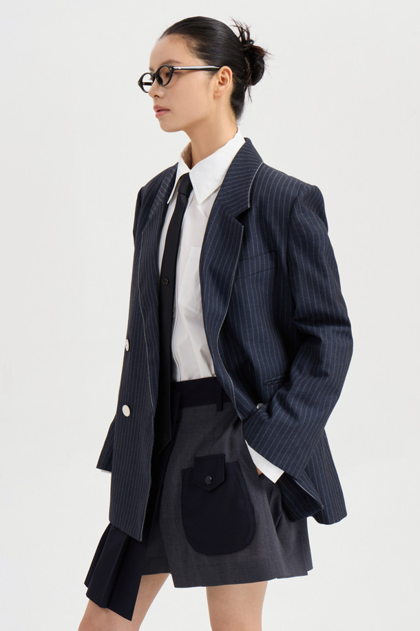 마테리얼 믹스 플리츠 쇼츠 (다크 네이비)는 유니크하면서도 클래식한 무드를 자아내는 여성 숏팬츠입니다. 부드러운 폴리에스터와 레이온 소재를 믹스하여 편안한 착용감을 선사하며, 무릎 위 기장의 A라인 핏으로 다리가 길어 보이는 효과를 줍니다. 스커트처럼 보이는 플리츠 디테일과 입체 포켓 디자인이 특징이며, 데이트룩, 카페룩, 모임룩 등 다양한 TPO에 맞춰 클래식, 미니멀, 걸리시 스타일을 연출할 수 있습니다. 간절기에 활용하기 좋은 아이템입니다.
