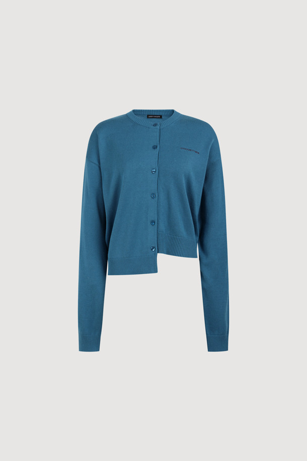 럭키슈에뜨의 Chouetties(슈에티) 언밸런스 니트 가디건 (블루)입니다. 아크릴과 코튼 혼방 소재로 제작되어 부드러운 촉감을 자랑하며, 가을, 겨울 시즌에 따뜻하게 착용할 수 있습니다. 캐주얼 스타일의 라운드넥 긴소매 가디건으로, 언밸런스한 기장감과 레터링 패턴이 특징입니다. 세 가지 모양의 믹스 단추 디테일이 돋보이며, 루즈핏으로 편안하게 착용 가능한 데일리 아이템입니다.
