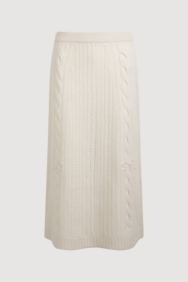 **Ribbon Knit Skirt (아이보리)**

부드러운 메리노울 소재의 리본 니트 스커트입니다. 세미 A라인 핏과 맥시 기장으로 우아한 실루엣을 연출하며, 케이블 및 립조직 패턴이 고급스러운 분위기를 더합니다. 밑단 립조직과 리본 디테일이 돋보이며, 두꺼운 두께감으로 따뜻하게 착용 가능합니다. 가을, 겨울 시즌 데이트룩, 모임룩, 출근룩 등 다양한 TPO에 활용 가능하며, 클래식, 미니멀, 걸리시 스타일을 즐기는 여성분들께 추천합니다. 체형 커버에도 효과적이며 세트업으로도 활용할 수 있습니다.
