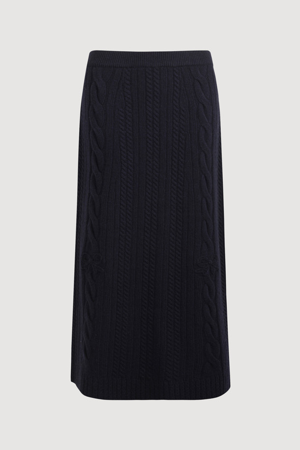 다크 네이비 색상의 리본 니트 스커트입니다. 메리노 울 소재로 제작되어 부드러운 촉감과 따뜻함을 선사하며, 가을/겨울 시즌에 적합합니다. 세미 A라인 핏에 밑단 립조직과 케이블/립조직 패턴이 우아하고 클래식한 분위기를 연출합니다. 허리 부분의 리본 디테일이 여성스러운 포인트를 더하며, 체형 커버에도 효과적입니다. 출근룩과 모임룩 모두 소화 가능한 활용도 높은 맥시 스커트로, 셋업 연출도 가능합니다.
