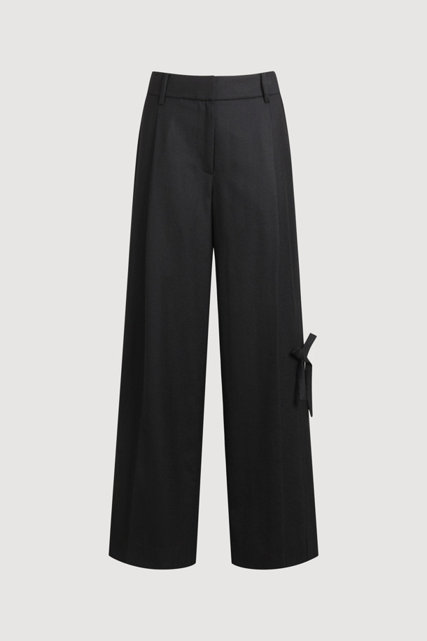 리본 포인트 울 와이드 팬츠 (블랙)는 여성스러운 실루엣을 완성하는 클래식 & 모던 스타일의 바지입니다. 고급스러운 울 100% 소재로 제작되어 부드러운 촉감과 두꺼운 두께로 따뜻하게 착용할 수 있습니다. 허리 배색과 턱 디테일이 특징이며, 루즈핏 와이드 디자인으로 편안하면서도 세련된 핏을 연출합니다. 

오피스룩, 모임룩, 겨울 데일리룩 등 다양한 TPO에 활용 가능하며, 미니멀, 시크 스타일을 즐기는 분들께 추천합니다. 지퍼 클로징과 리본 디테일이 섬세함을 더해줍니다. 맥시 기장의 무지 디자인으로 어떤 상의와도 쉽게 매치할 수 있습니다.
