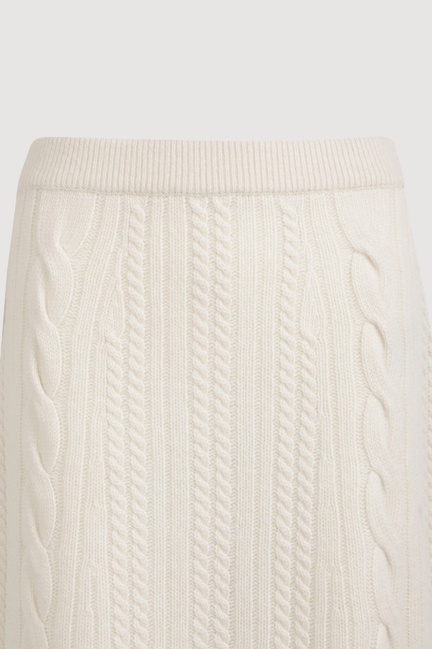 **Ribbon Knit Skirt (아이보리)**

부드러운 메리노울 소재의 리본 니트 스커트입니다. 세미 A라인 핏과 맥시 기장으로 우아한 실루엣을 연출하며, 케이블 및 립조직 패턴이 고급스러운 분위기를 더합니다. 밑단 립조직과 리본 디테일이 돋보이며, 두꺼운 두께감으로 따뜻하게 착용 가능합니다. 가을, 겨울 시즌 데이트룩, 모임룩, 출근룩 등 다양한 TPO에 활용 가능하며, 클래식, 미니멀, 걸리시 스타일을 즐기는 여성분들께 추천합니다. 체형 커버에도 효과적이며 세트업으로도 활용할 수 있습니다.
