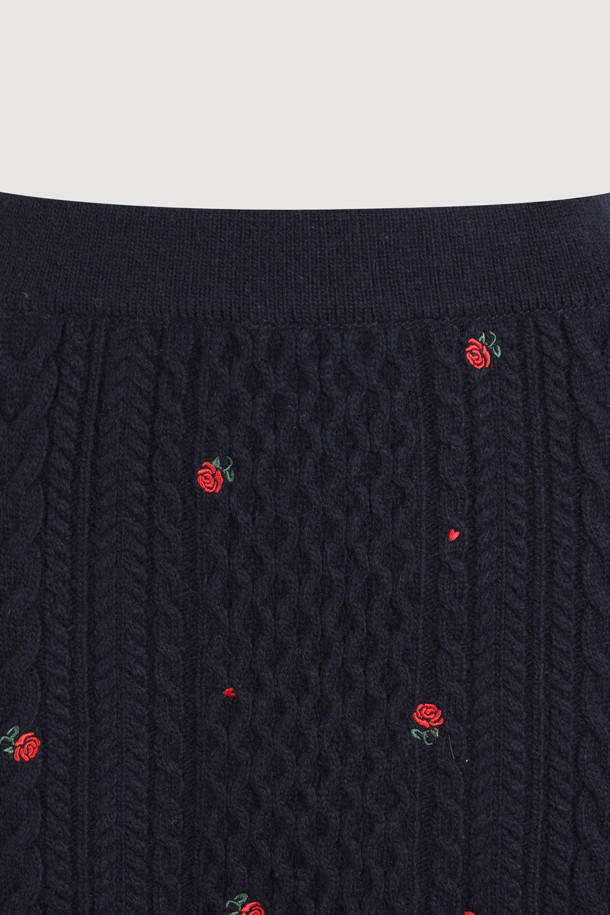 다크 네이비 컬러의 케이블 자수 니트 스커트입니다. 울, 캐시미어, 나일론 혼방 소재로 제작되어 부드러운 촉감과 두꺼운 두께감으로 따뜻하게 착용할 수 있습니다. H라인 미니스커트 디자인에 허리 밴딩, 자수 디테일, 니트 조직감이 더해져 미니멀하면서도 베이직한 스타일을 연출합니다. 가을, 겨울 시즌 데이트룩, 출근룩, 모임룩 등 다양한 TPO에 클래식, 미니멀, 시크한 무드로 활용하기 좋습니다. 레귤러핏으로 편안하게 착용 가능하며, 케이블 패턴과 플라워 자수 무늬가 특징입니다.
