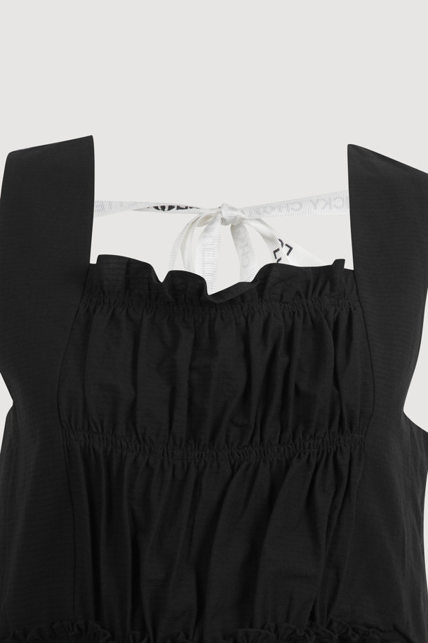 "Back Lettering Strap Shirring Top Blouse (black)"는 시원한 여름을 위한 여성용 민소매 블라우스입니다. 무지 패턴의 블랙 컬러에 스퀘어넥 디자인과 셔링 & 티어드 디테일, 미디 길이로 캐주얼한 스타일을 연출합니다. 얇은 두께감과 루즈핏으로 편안하게 착용 가능하며, A라인 치마 타입입니다.
