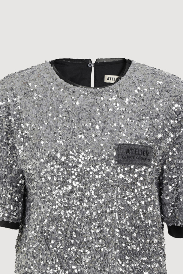 [Atelier] 스팽글 하프 슬리브 블라우스 (실버)는 여성 고객을 위한 블라우스입니다. 벨벳 소재에 실버 컬러의 스팽글 장식이 더해져 화려하면서도 유니크한 스타일을 연출합니다. 반소매 기장의 일자핏 블라우스로, 뒤 단추 여밈과 네크라인, 소매단, 밑단의 시어 배색이 특징입니다. 가슴 부분의 니트 장식이 포인트로, 파티룩, 연말 모임룩, 모임룩 등 TPO에 활용 가능하며, 클래식, 시크, 미니멀 스타일을 선호하는 고객에게 추천합니다.
