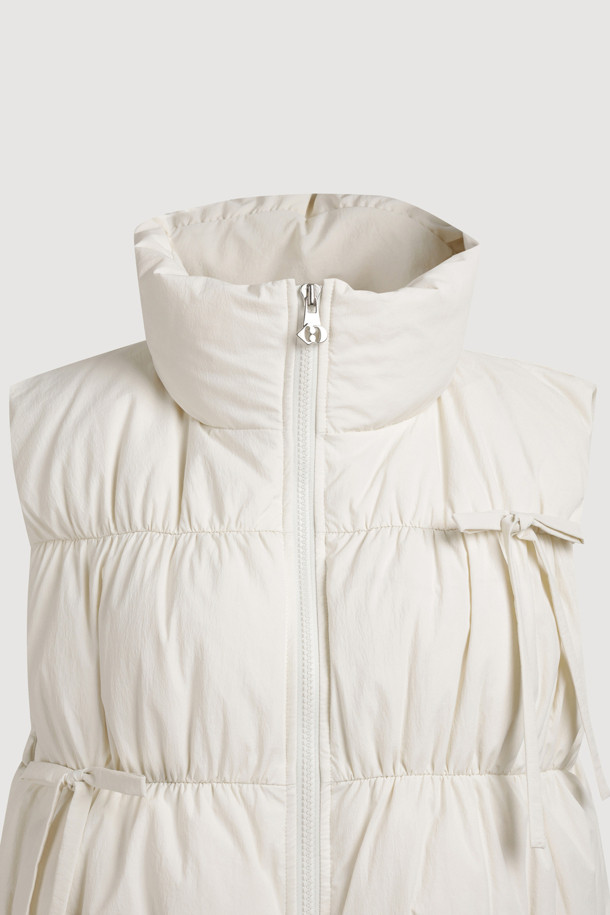 리본 디테일이 돋보이는 [Re-Order] 리본 다운 베스트는 페미닌한 무드를 연출합니다. 부드러운 유연함을 자랑하는 나일론, 스판덱스 혼방 소재로 제작되어 편안한 착용감을 선사합니다. 숏 기장과 투웨이 지퍼 여밈으로 세련된 실루엣을 강조하며, 셔링 디테일과 샤이니 안감이 고급스러움을 더합니다. 데이트룩, 모임룩 등 다양한 TPO에 활용 가능한 아이보리 컬러의 겨울철 필수 아이템입니다. 구스다운 충전재와 패딩 안감으로 보온성을 높였습니다.
