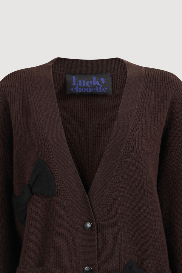 [Re-Order] Ambo 리본 니트 가디건 (브라운)은 울과 코튼 혼방 소재로 제작되어 부드러운 촉감과 따뜻함을 선사합니다. 라운드넥에 긴 소매 기장, 루즈핏으로 편안한 착용감을 제공하며, 클래식과 캐주얼 스타일을 모두 소화할 수 있습니다. 금속 단추와 니팅 리본 디테일, 포켓 디테일이 디자인 포인트이며, 가을, 겨울 시즌 데이트룩, 카페룩, 데일리룩에 활용하기 좋습니다. 두꺼운 두께감으로 오버핏 아우터 안에 이너로도 활용 가능하며, 타이트한 이너와 데님 하의와 함께 코디하면 멋스럽습니다.
