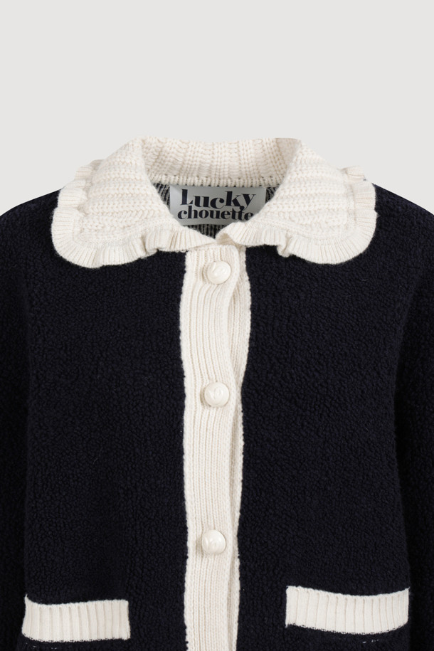 다크 네이비 컬러의 Colored Collar 니트 풀오버입니다. 부드러운 울 소재로 제작되어 가을과 겨울에 따뜻하게 착용할 수 있습니다. 페미닌하고 캐주얼한 무드를 연출하며, 루즈핏과 긴 소매 기장으로 편안함을 더했습니다. 배색 프릴 카라와 금속 버튼, 앞 포켓, 뒷면 그래픽 디자인이 특징입니다. 데이트룩, 모임룩, 캐주얼, 클래식, 미니멀 스타일 모두 소화 가능한 아이템입니다.
