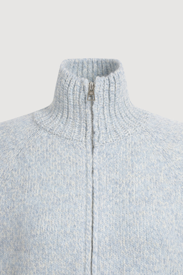 라이트 블루 컬러의 자수 포인트 집업 니트 가디건입니다. 래글런 소매와 하이넥 디자인으로 따뜻함과 스타일을 동시에 잡았습니다. 두꺼운 두께감의 니트 소재에, MULINE 타입 원사를 사용하여 포근한 착용감을 선사합니다. 등판 로고와 핸드메이드 자수 디테일이 유니크한 포인트를 더하며, 밑단 러플과 페플럼 디자인으로 여성스러운 실루엣을 연출합니다. 금속 지퍼로 간편하게 여밀 수 있으며, 가을, 겨울철 캐주얼 룩에 활용하기 좋습니다.
