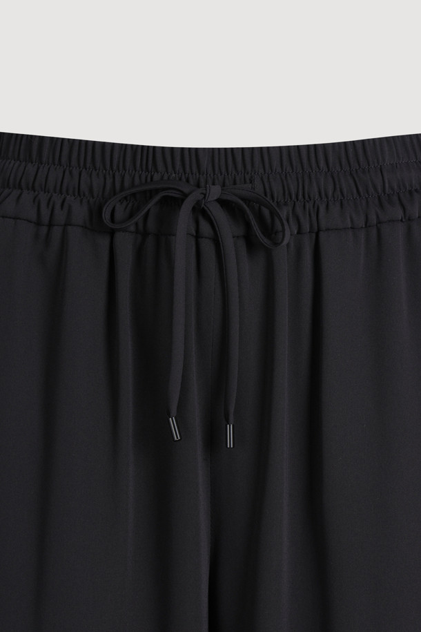 블랙 색상의 사이드 라인 포인트 팬츠입니다. 얇은 두께감으로 여름철에도 시원하게 착용 가능하며, 와이드핏과 부드러운 촉감이 편안한 착용감을 선사합니다. 캐주얼, 미니멀, 스트리트 스타일을 모두 소화할 수 있으며, 동네 마실룩이나 여행룩에 적합합니다. 허리 스트링과 좌측 사이드 포켓, 로고 패치 디테일이 특징입니다. 밴딩 처리된 긴 기장의 와이드핏 바지입니다.
