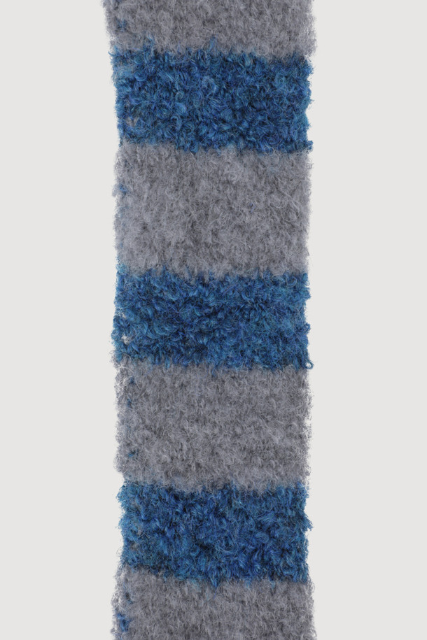 [Re-Order] 슈에티 by 럭키슈에뜨_스트라이프 니트 머플러(블루)는 캐주얼 및 미니멀 스타일을 즐겨 입는 분들을 위한 머플러입니다. 얇은 두께감과 보온성을 갖춘 울 소재로 제작되어 가을, 겨울철 출근룩에 포인트를 더하기 좋습니다. 블루와 그레이 컬러의 스트라이프 패턴이 세련된 느낌을 주며, 럭키 크레센트 문 모티브 와펜 자수가 은은하게 디자인되어 있습니다. 얇고 긴 형태로 제작되어 다양한 스타일로 연출 가능하며, 웨어러블한 디자인으로 데일리하게 활용하기 좋습니다.
