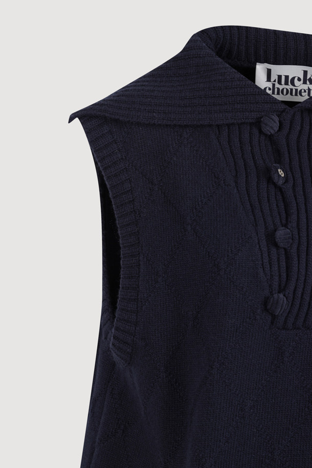 베스트  knit 드레스 (dark navy)는 부드러운 울, 나일론, 캐시미어 혼방 소재로 제작되어 포근한 착용감을 선사합니다. 톤 다운된 다크 네이비 컬러와 아가일 패턴이 클래식하면서도 캐주얼한 무드를 자아냅니다. 민소매 디자인에 하이넥 베스트 연출이 가능하며, 레이어드 스타일링으로 다양한 분위기를 연출할 수 있습니다. 넉넉한 루즈핏으로 편안하며, 세일러 카라 디테일이 사랑스러운 포인트를 더합니다. 속주머니가 있어 실용적이며, 가을, 겨울철 데일리룩, 모임룩, 카페룩 등 폭넓게 활용하기 좋습니다.

