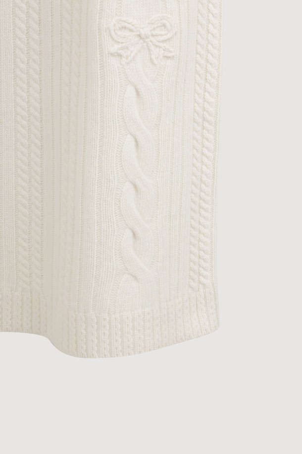 **Ribbon Knit Skirt (아이보리)**

부드러운 메리노울 소재의 리본 니트 스커트입니다. 세미 A라인 핏과 맥시 기장으로 우아한 실루엣을 연출하며, 케이블 및 립조직 패턴이 고급스러운 분위기를 더합니다. 밑단 립조직과 리본 디테일이 돋보이며, 두꺼운 두께감으로 따뜻하게 착용 가능합니다. 가을, 겨울 시즌 데이트룩, 모임룩, 출근룩 등 다양한 TPO에 활용 가능하며, 클래식, 미니멀, 걸리시 스타일을 즐기는 여성분들께 추천합니다. 체형 커버에도 효과적이며 세트업으로도 활용할 수 있습니다.
