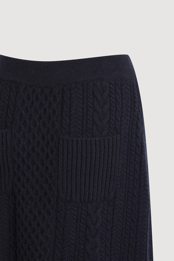다크 네이비 컬러의 케이블 자수 니트 스커트입니다. 울, 캐시미어, 나일론 혼방 소재로 제작되어 부드러운 촉감과 두꺼운 두께감으로 따뜻하게 착용할 수 있습니다. H라인 미니스커트 디자인에 허리 밴딩, 자수 디테일, 니트 조직감이 더해져 미니멀하면서도 베이직한 스타일을 연출합니다. 가을, 겨울 시즌 데이트룩, 출근룩, 모임룩 등 다양한 TPO에 클래식, 미니멀, 시크한 무드로 활용하기 좋습니다. 레귤러핏으로 편안하게 착용 가능하며, 케이블 패턴과 플라워 자수 무늬가 특징입니다.
