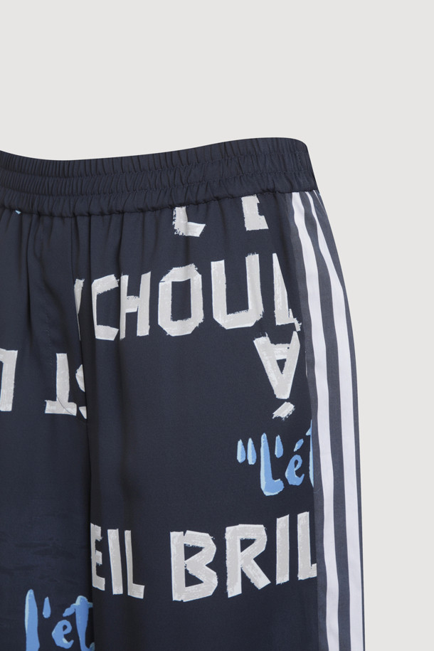 다크 네이비 컬러의 Side Coloring Print Banding Pants는 시원한 폴리에스터 소재로 제작되어 여름철에도 쾌적하게 착용할 수 있습니다. 와이드 핏으로 편안함을 강조하며, 옆라인 스트라이프 배색과 럭키슈에뜨 레터링 프린트가 캐주얼한 스타일을 연출합니다. 맥시 기장의 와이드 팬츠로, 밴딩 처리되어 활동성 또한 높습니다.
