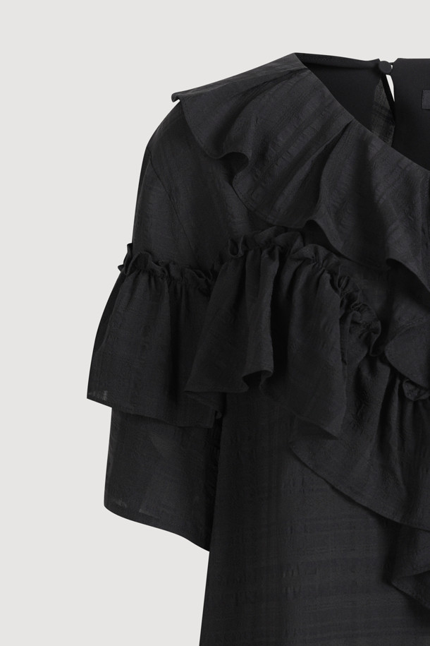 **러플 포인트 체크 블라우스 (블랙)**

페미닌한 무드의 여성 블라우스입니다. 봄, 여름 시즌에 어울리는 얇은 두께감의 폴리에스테르, 레이온 혼방 소재로 제작되었습니다. 루즈핏에 V넥 디자인이며, 러플 디테일과 비대칭 네크라인이 특징입니다. 반소매 소매 셔링과 뒷넥 단추 여밈으로 여성스러운 포인트를 더했습니다. 데이트룩, 카페룩, 모임룩 등 다양한 TPO에 클래식, 미니멀, 로맨틱 스타일로 연출하기 좋습니다.
